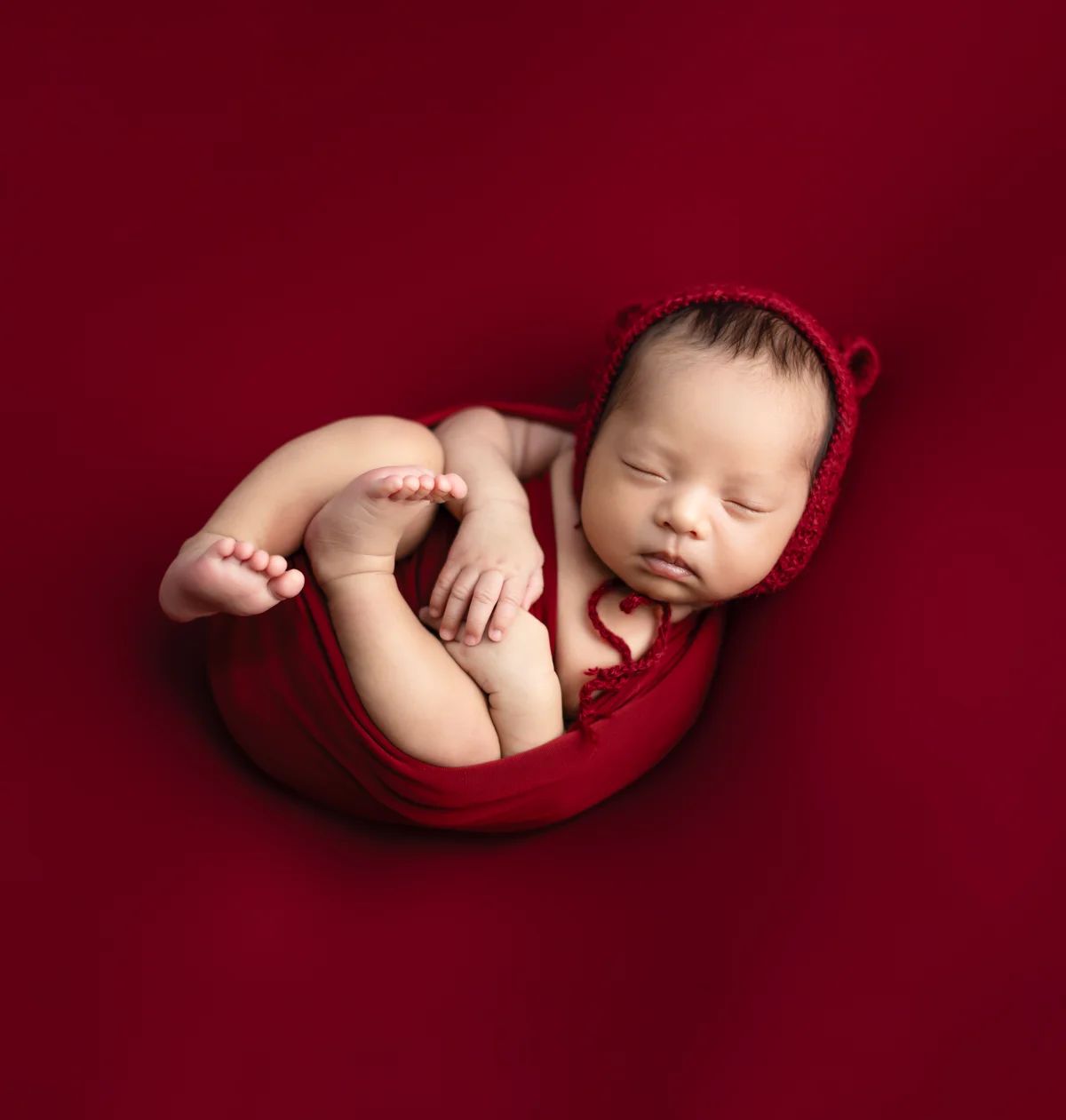 Newborn baby photography session — tiny sleeping infant wrapped in soft fabric at Cute Galleries, Kathmandu